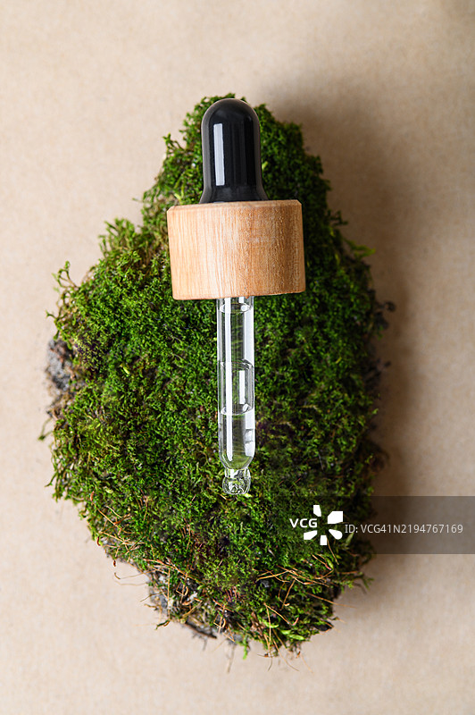 木盖滴管置于苔藓背景上图片素材