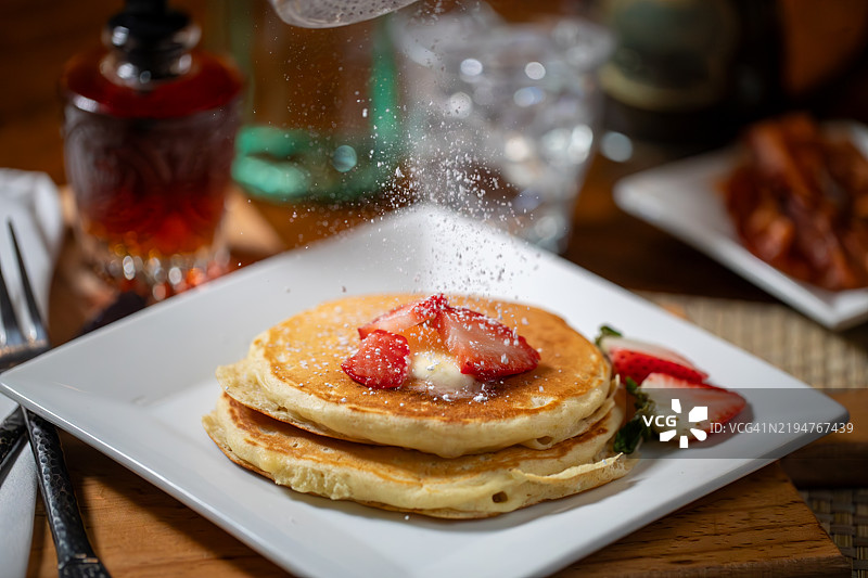 撒上糖粉的煎饼和草莓的动态镜头图片素材