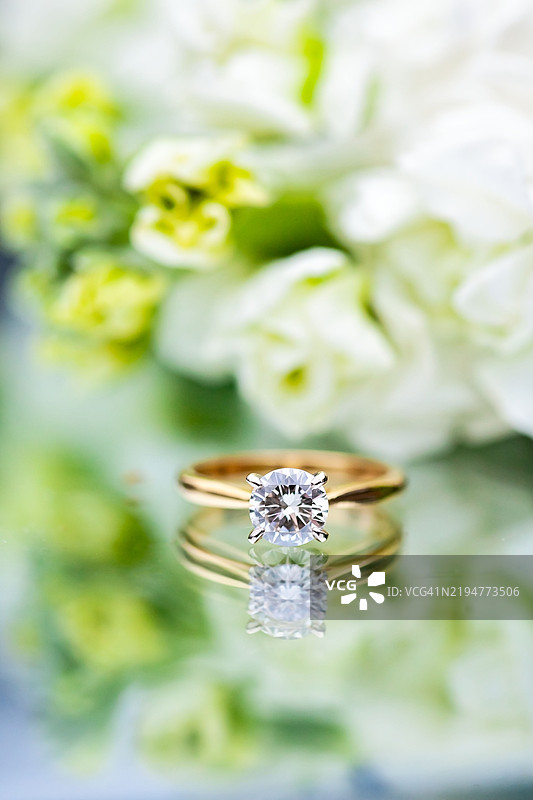 花朵旁的钻石戒指特写图片素材