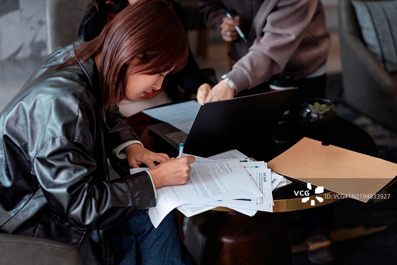 专注的实习生在团队讨论中做笔记图片素材