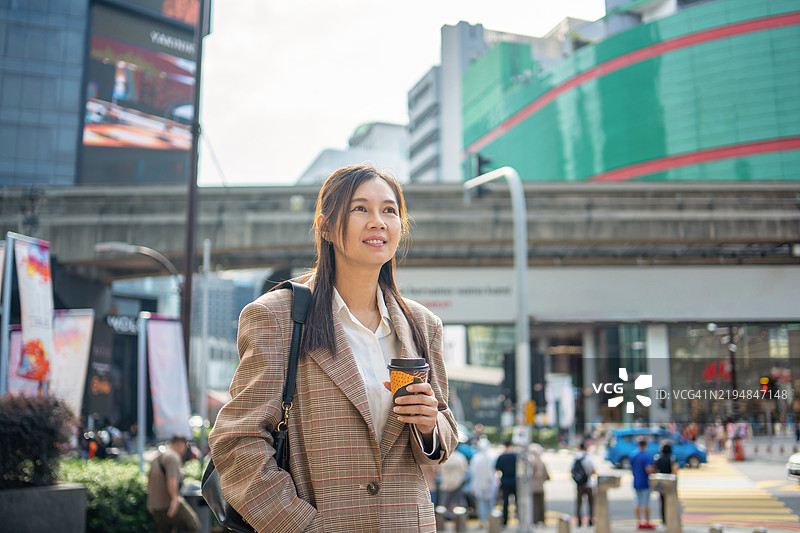 女商人带着咖啡杯通勤上班图片素材