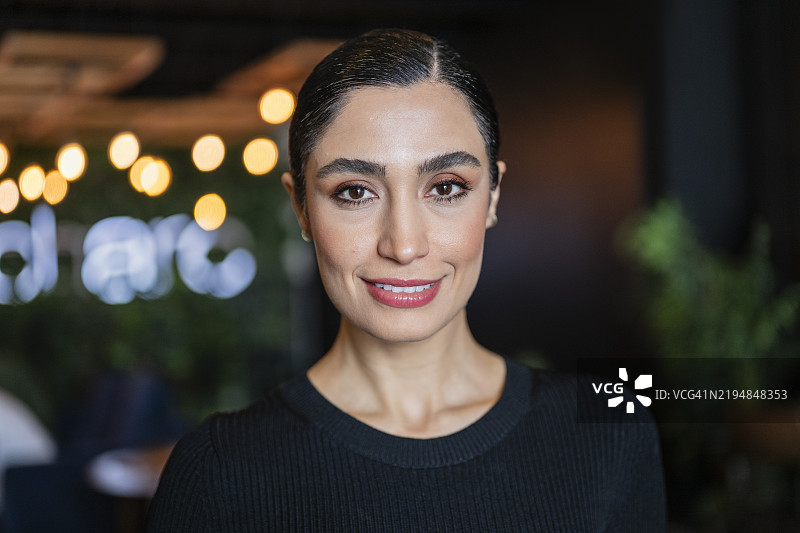 穿着黑色上衣、微笑的迷人伊朗女商人的头像图片素材