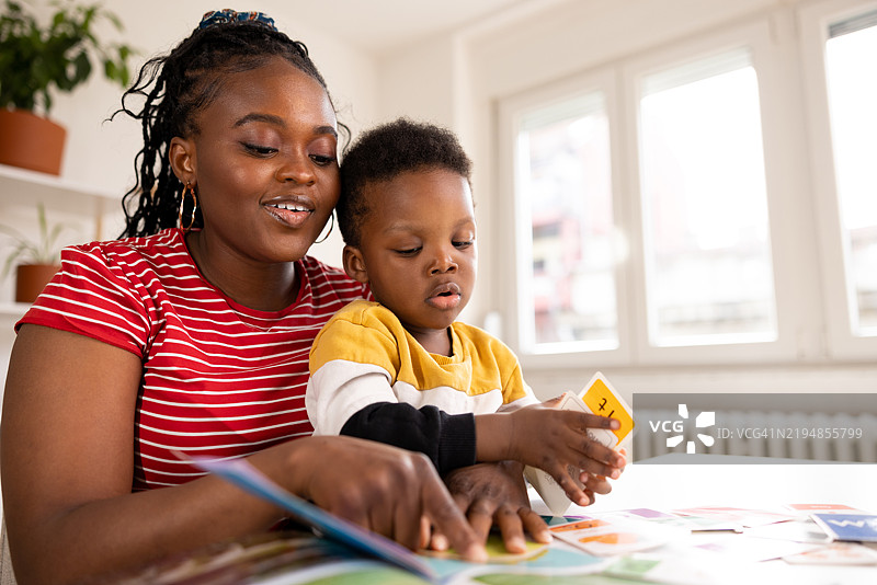 母亲在家帮助儿子学习数字和字母图片素材