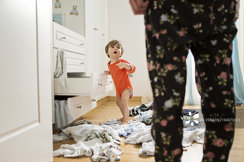 幼儿在卧室里制造混乱，衣服到处都是图片素材