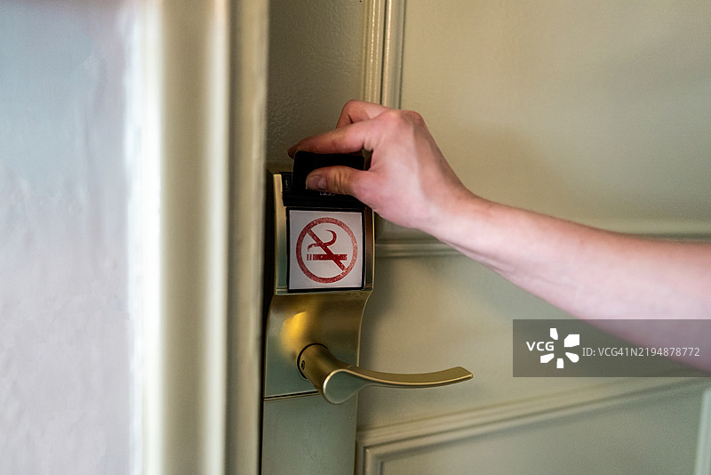 一位女性使用房卡开酒店门的特写镜头图片素材