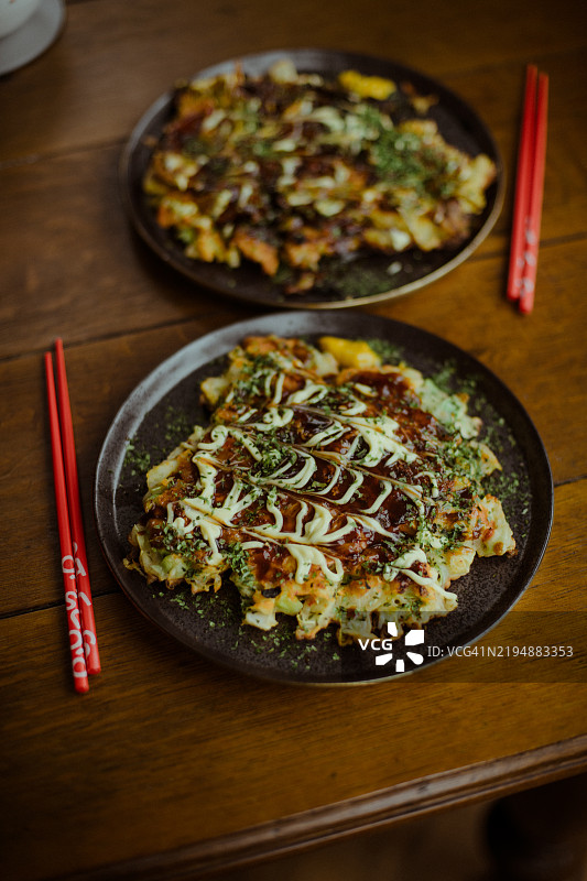 精致盘子上的家常御好烧与筷子图片素材