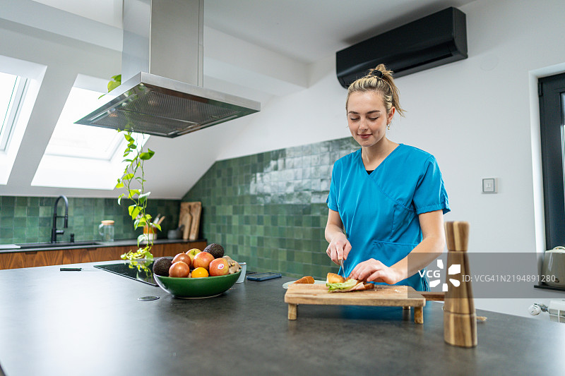 一位年轻护士在上班前准备营养丰富的早餐图片素材