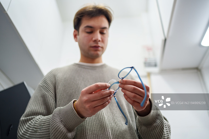 眼镜店男士正在用工具修理眼镜和镜框。图片素材
