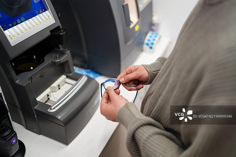 眼镜师正在用工具修理眼镜和镜框。图片素材