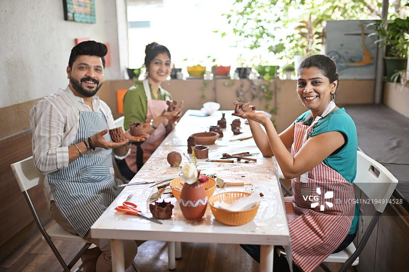 参与者在艺术工作室的工作坊中展示他们的陶土创作图片素材
