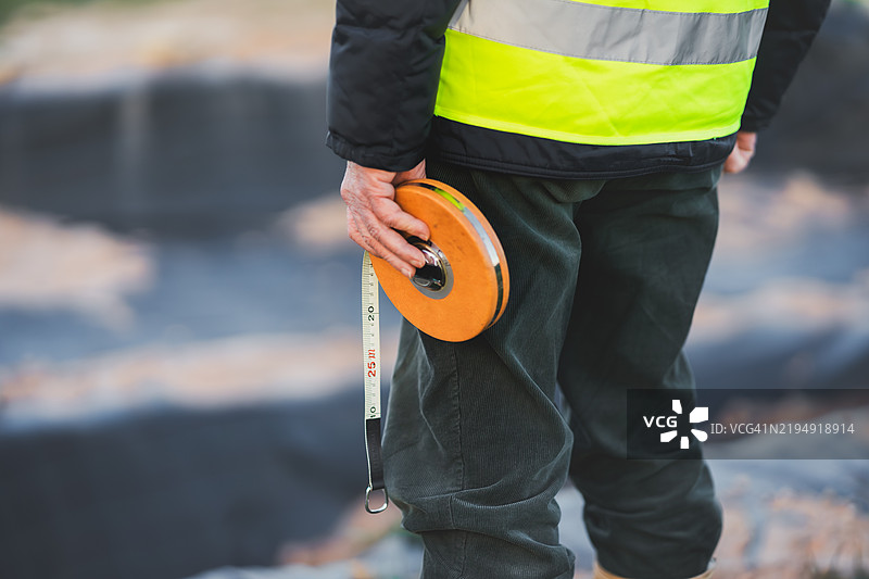 考古学家在挖掘现场手持测量带图片素材