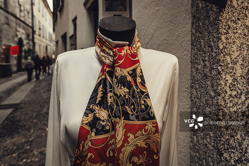 穿着白色上衣和五彩围巾的模特，意大利小镇的购物街图片素材