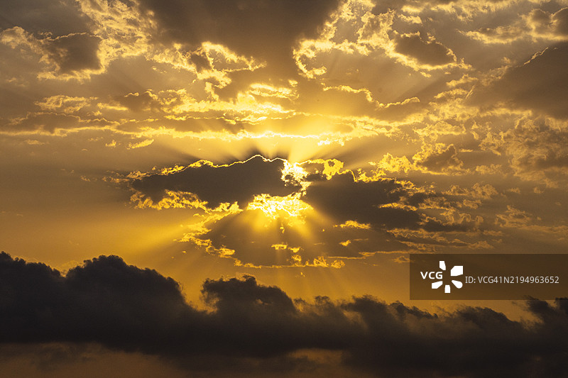 夕阳下阳光透过云层的低角度视图图片素材