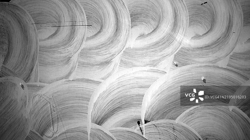 圆形和有纹理的白色油漆层覆盖在玻璃上。两小片白纸贴在窗户上。明亮的光线。阴影。图片素材