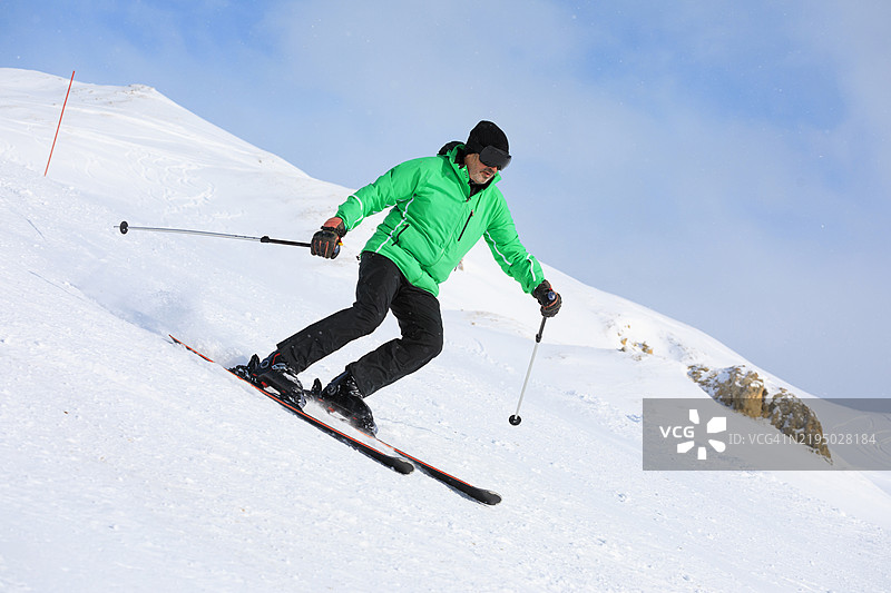 滑雪冬季运动。充满活力的男性滑雪者在阳光明媚的滑雪度假村享受滑雪乐趣，期待下雪。欧洲阿尔卑斯山的雪山，滑雪区域瓦尔迪泽尔 - 蒂涅。图片素材