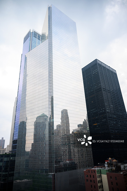 纽约市中心的蓝色玻璃企业大楼，映衬着周围的景象图片素材