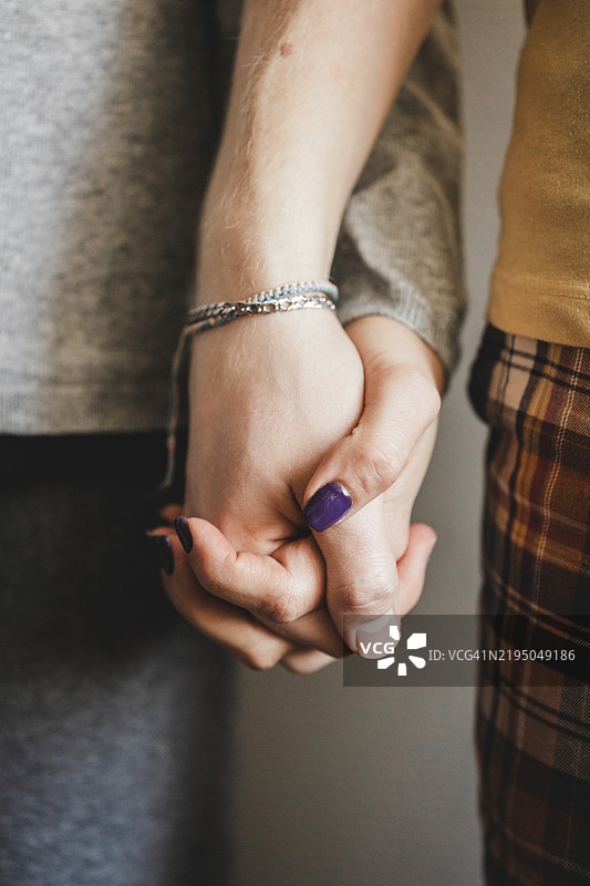 年轻情侣手牵手，特写镜头。图片素材