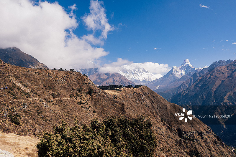 远景拍摄的山脉，包括阿玛达布朗山，远处有一条徒步小径。图片素材