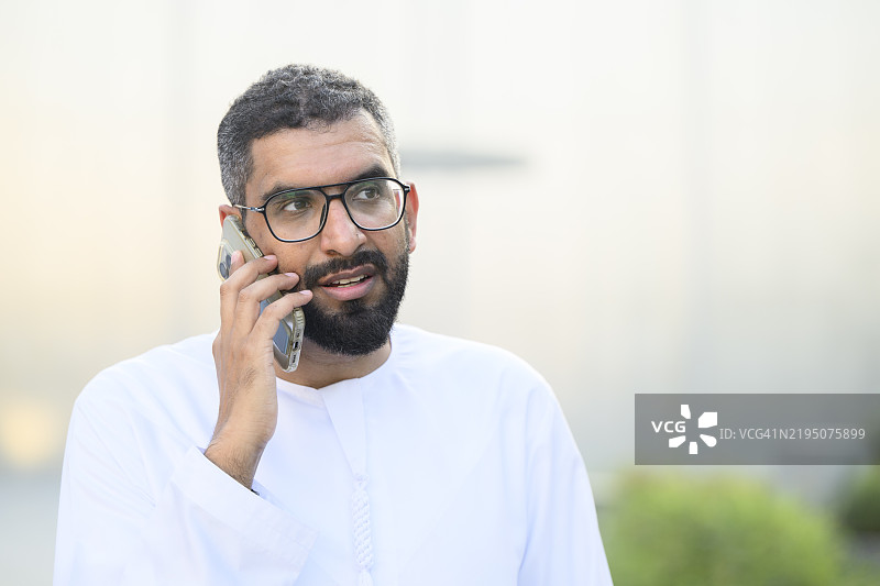 阿联酋商人在户外使用智能手机通话图片素材