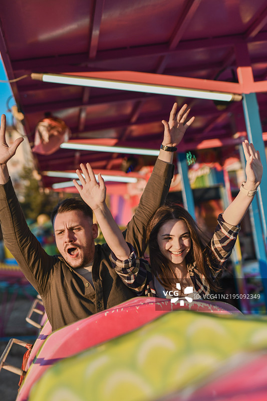 快乐的朋友们在刺激的过山车上举起双臂尽情享受图片素材