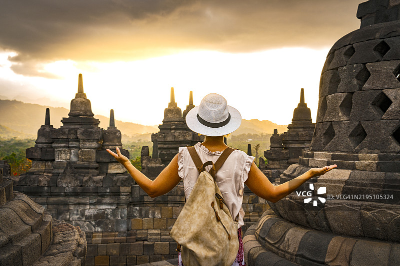 女人在日落时欣赏婆罗浮屠寺庙图片素材