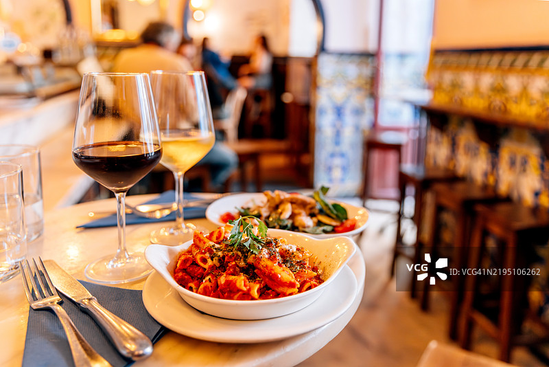 西班牙马德里餐厅提供的番茄笔管面和葡萄酒图片素材