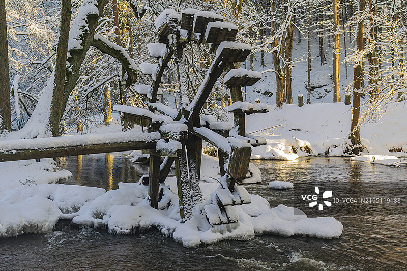 冬季森林中被雪覆盖的水车，位于上巴伐利亚的瓦尔德纳布塔尔图片素材