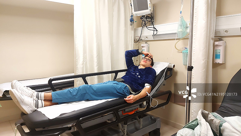 年轻男孩在医院急诊室接受静脉输液图片素材