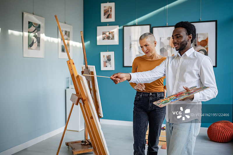 艺术家们在充满生机灵感和动态表现的艺术工作室中进行创意合作图片素材