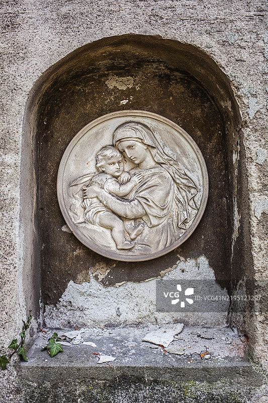 玛丽抱着婴儿耶稣，石雕浮雕，风化的墓碑，瓦森教堂墓地，莱奥本，施蒂利亚，奥地利，欧洲图片素材