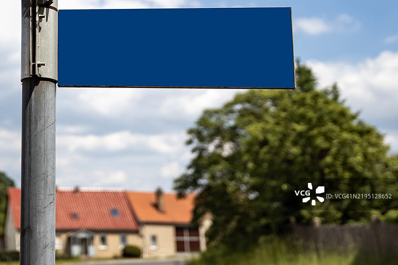 德国一个小传统村庄中的空白蓝色路标图片素材
