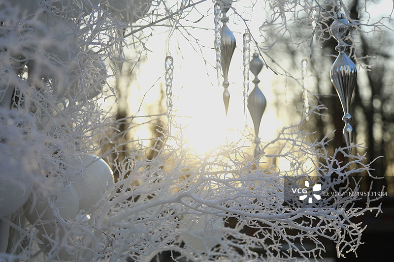 全景节日装饰的人工圣诞树，闪闪发光的花环、白色球饰和冰柱，阳光明媚的冬日时刻图片素材