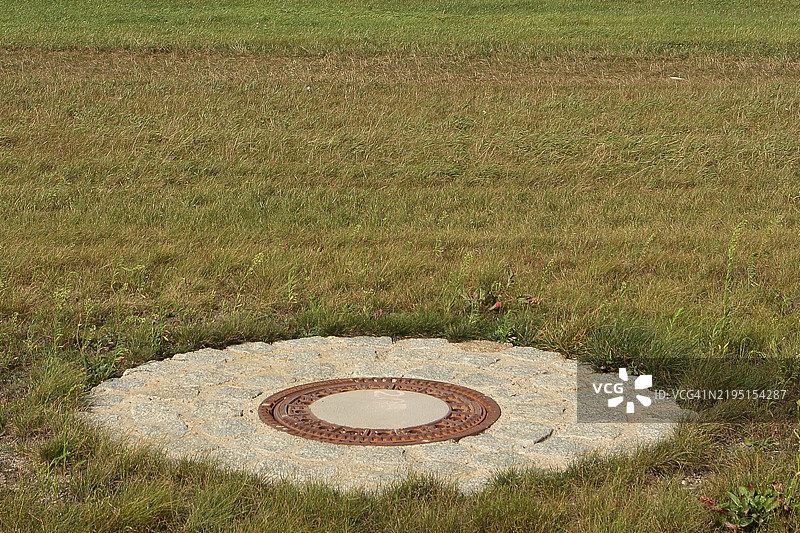 草地上的井盖图片素材