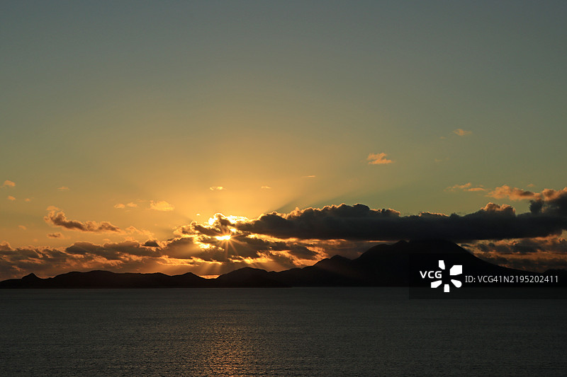 东加勒比海的云层和山脉轮廓后方的日出图片素材