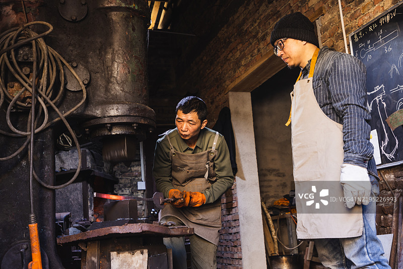 亚洲铁匠教徒弟锻造金属图片素材