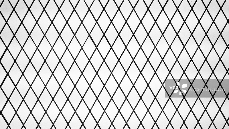 白色菱形马赛克与黑色接缝的特写，位于墙面上。加拿大魁北克省蒙特利尔。阳光。黑白色调。图片素材