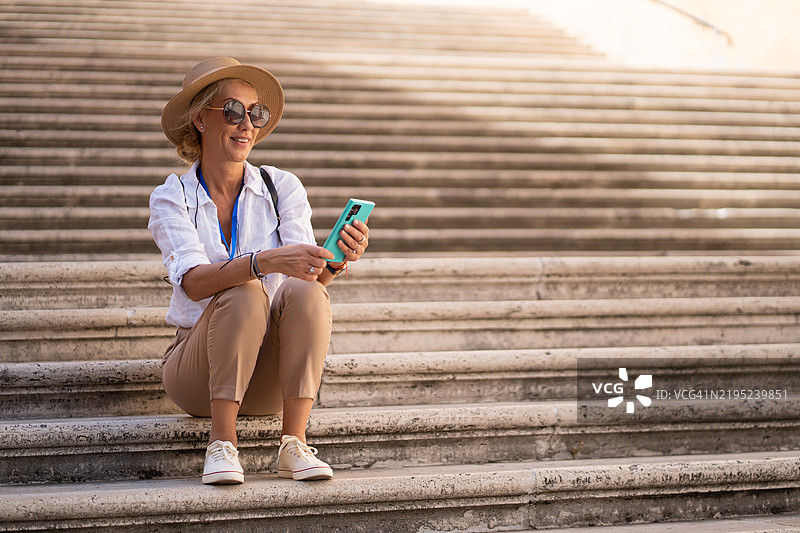 坐在意大利罗马历史中心的卡比托利欧广场新宫殿台阶上的女人图片素材