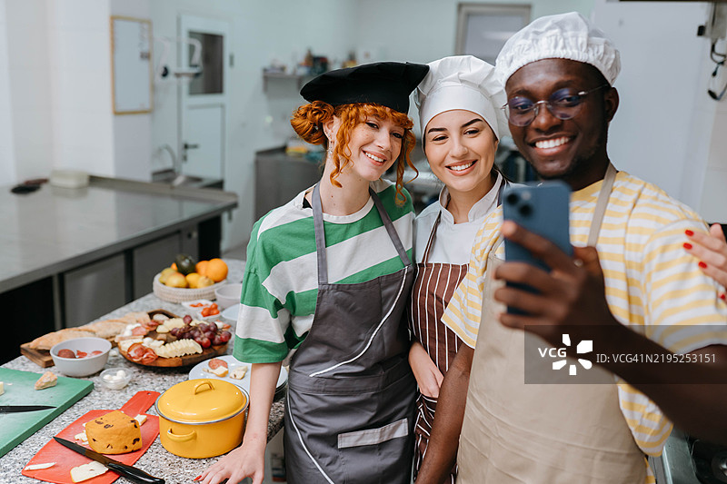 在烹饪工作坊中与朋友们一起自拍的活泼讲师图片素材