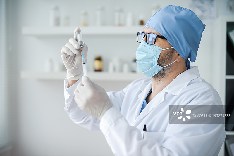 男性医生手持疫苗注射用药瓶图片素材