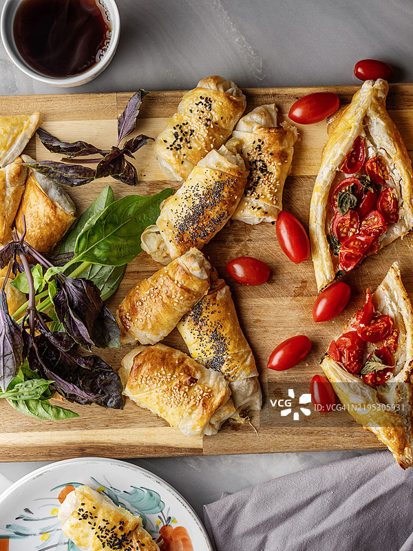 土耳其皮塔饼。土耳其披萨。玛格丽塔扁面包披萨。带酥皮的土耳其披萨放在板上。自制菲达奶酪酥皮点心。番茄和罗勒的酥皮饼。咸味塔。番茄奎什。番茄塔。美味的新鲜奶酪皮塔饼。图片素材