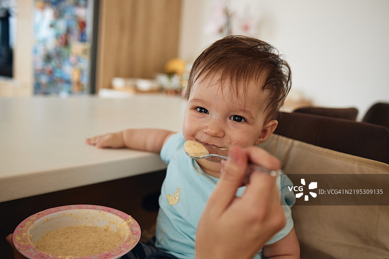快乐的男婴与母亲一起吃饭图片素材