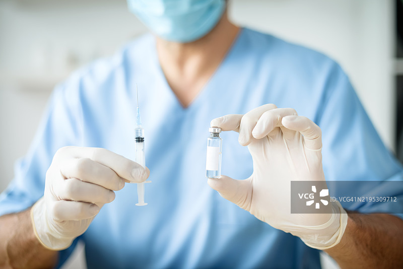 男性医生手持疫苗注射用药瓶图片素材