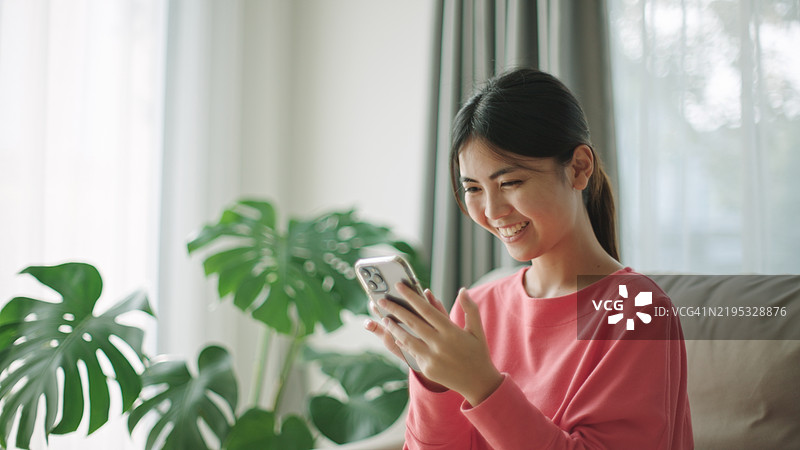 青少年在沙发上使用智能手机。图片素材