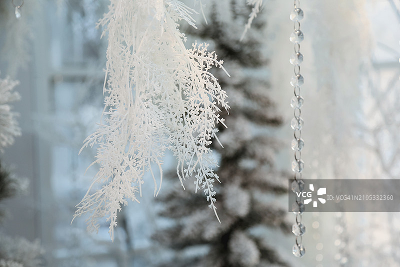 节日新年背景。全景人工圣诞树，装饰着闪闪发光的花环。白色、银色和柔和色调。图片素材