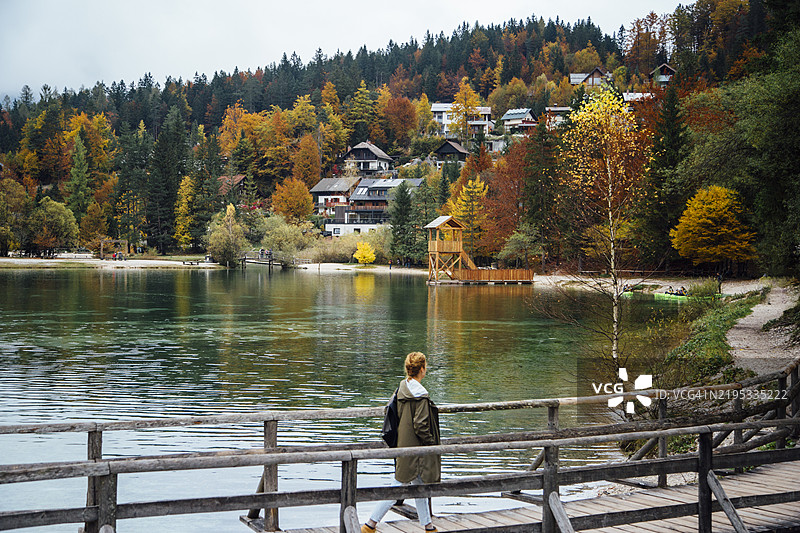 女人在湖岸前探索令人惊叹的村庄景色图片素材
