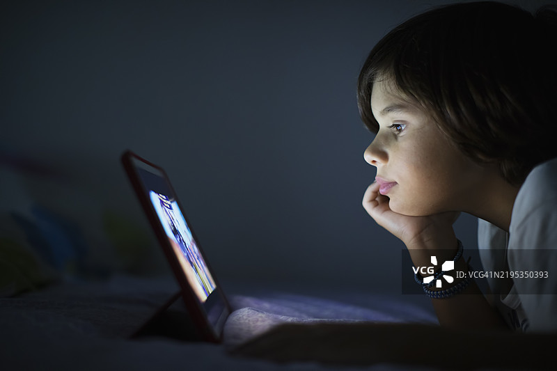 男孩在昏暗的房间里看着屏幕图片素材