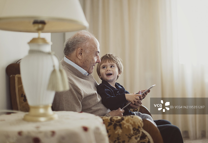 祖父与孙子在家中愉快互动图片素材