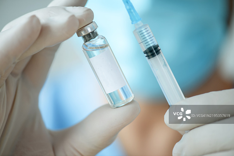 男性医生手持疫苗注射用药瓶图片素材