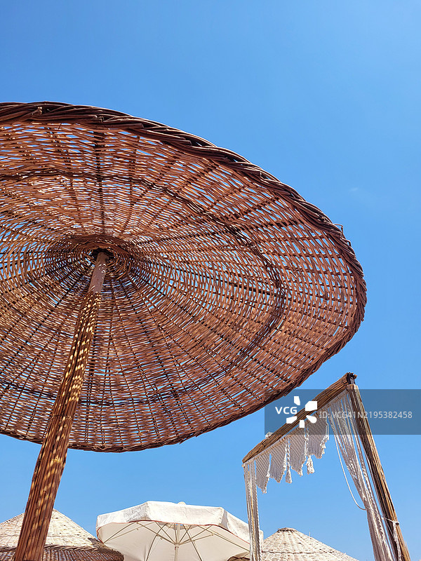 低角度视图下的阳伞与晴朗的蓝天图片素材