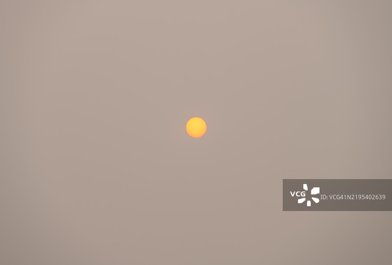 太阳在尘埃和雾霾云层后升起。图片素材